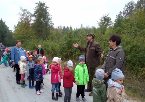 dzieci z nauczycielkami idą drogą przy lesie