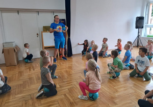 przedszkolaki siedzą i słuchają trenera