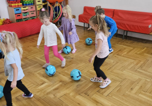 dzieci starają się lekko kopać piłkę