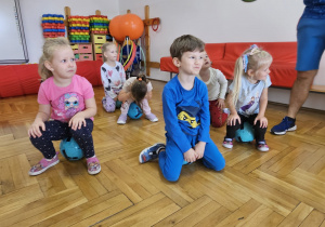 dzieci siedzą na piłkach w bezruchu