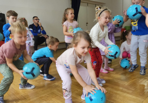 przedszkolaki odbijają piłki o podłogę