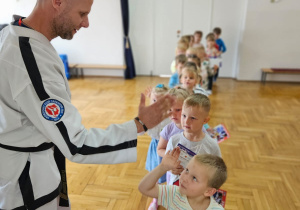dzieci przybijają piątkę z trenerem