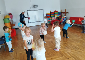 dzieci w parach rzucają piłki do siebie