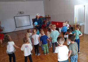 dzieci stoją przed trenerem i słuchają jego poleceń