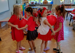 taniec w parach z czerwonymi balonami umieszczonymi między brzuchami dzieci