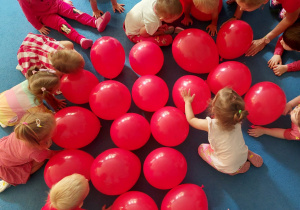 przedszkolaki biorą czerwone balony