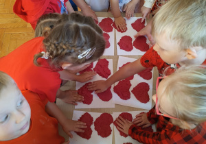 przedszkolaki ugiatają czerwone serduszka z masy solnej