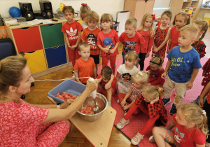 dzieci obserwują jak nauczycielka miażdży arbuza na sok