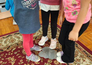 dzieci w grupie zgromadzone wokół zaznaczonego miejsca