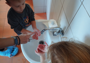 chłopiec dostaje mydło w płynie na ręce