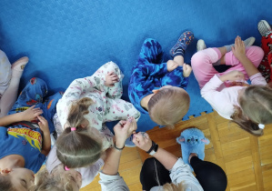 nauczycielka stawia stempelki na dłonich dzieci