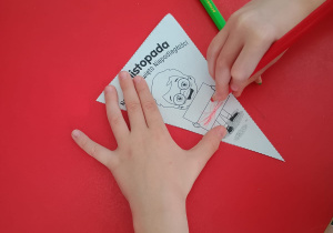 dziecko koloruje proporczyk z napisem 11 listopada