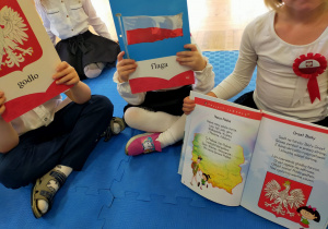 przedszkolaki trzymają ilustracje przedstawiające symbole narodowe