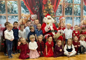 zdjęcie grupowe przedszkolaków z grupy IV z Mikołajem i nauczycielką