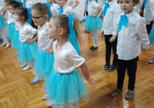 przedszkolaki stoją i śpiewają w szeregach
