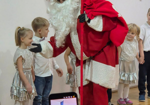 Mikołaj wita się z dziećmi stojącymi w kole