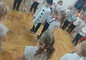 przedszkolaki stoją w półkolu wokół chłopca przebranego za bałwanka, chłopca i dziewczynki