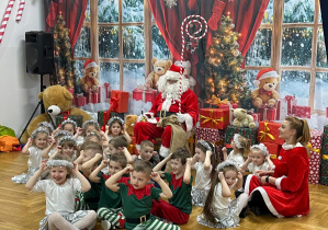dzieci siedzą przed Mikołajem z Mikołajką