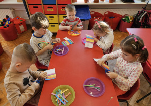 przedszkolaki wycinają paski kolorowego papieru