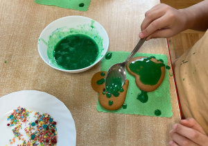 dzieci polewają kolorową polewą piernickiw kształcie serca