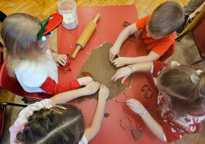 dzieci wyciskają pierniczki za pomocą foremek