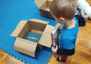 chłopiec wkłada upominki do tekturowego pudełka
