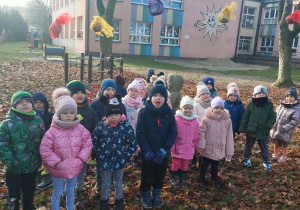 przedszkolaki w ogrodzie przedszkolnym patrzą na zawieszone kule tłuszczowe