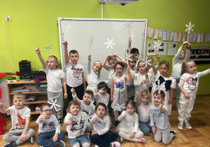 przedszkolaki trzymają śnieżynki na patykach
