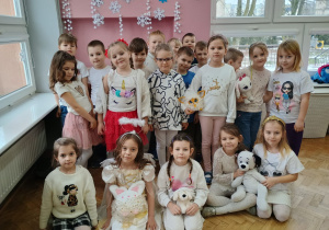 przedszkolaki w białych ubraniach z białymi maskotkami