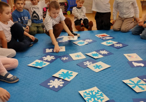 przedszkolaki układają kartki w pary ze śnieżynkami