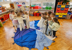 zabawa w kolory na chuście animacyjnej - dzieci ściskają się na kolorze białym