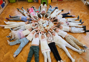 dzieci leżą tworząc z ciał śnieżynkę