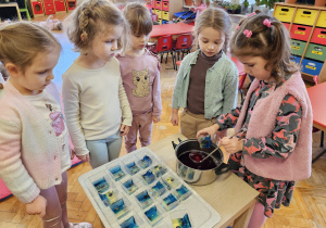 dziewczynka wlewa niebieską galaretkę do pojemnika
