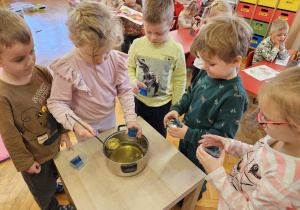 dziewczynka wlewa żółtą galaretkę do pojemnika