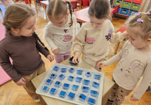 dziewczynki wrzucają borówki do niebieskiej galaretki