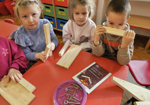 dzieci oglądają drewniane elementy na karmnik