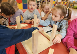 dzieci układają elementy karmnika