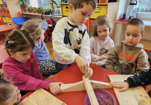 chłopiec skręca elementy karmnika z pomocą dzieci