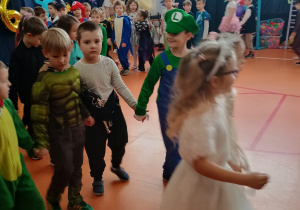 dzieci maszerują parami po obwodzie koła