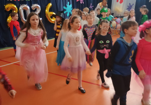 dzieci maszerują parami po obwodzie koła