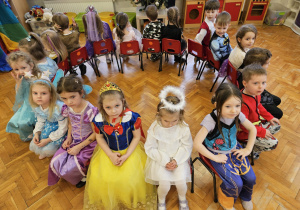 dzieci siedzą na krzesełkach ustawionych w kole