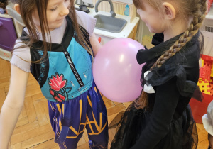 dziewczynki trzymają brzuchami balon tańcząc w parach