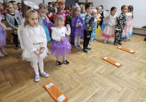 dzieci ustawione w rzędach ze ścierkami mopów