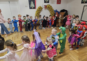 przedszkolaki tańczą w kole trzymając ręce na ramionach kolegi