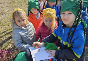 przedszkolaki zaznaczają na kartce wykonane zadanie