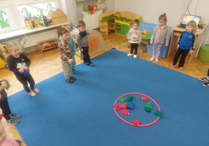 dzieci rzucają woreczki do dużego koła hula hop