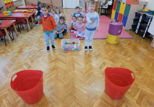 chłopcy rzucają piłeczkami do koszy i rywalizują mięzy sobą