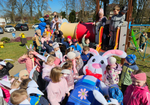 Zając zjężdża ze zjeżdżalni wśród dzieci