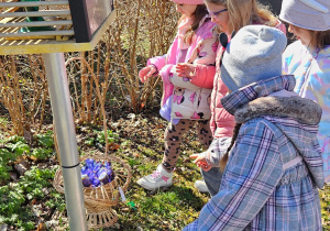 dziewczynki znajdują koszyk ze słodyczamipod stcją meteorologiczną