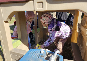 dziewczynki znajdują koszyczek w domku w ogrodzie